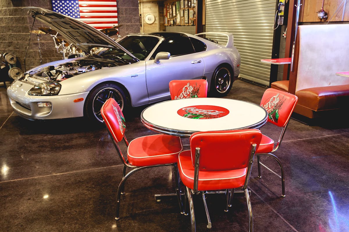 Branded table and chairs next to car at Hanks Garage Venue