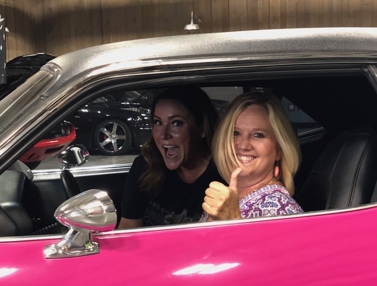 Happy women in pink car